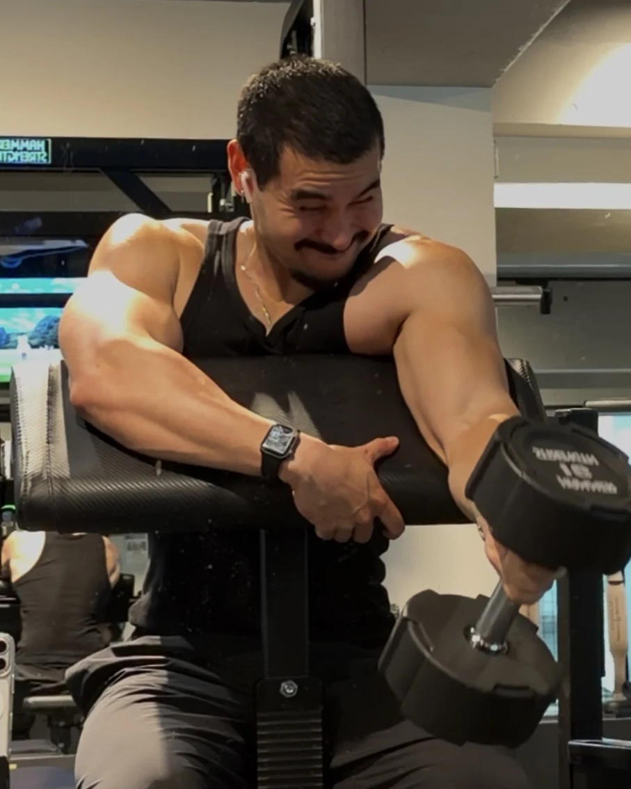 Brendan mid preacher curl with a dumbbell in a Tokyo gym